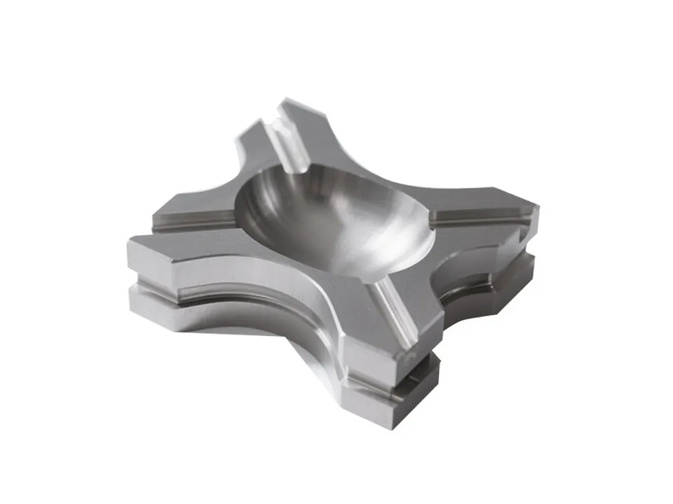 Stainless steel cross-shaped block with a spherical pocket, milled